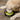 A golden retriever dog drinking from a black circular dog bowl with a bright yellow-green liner. The bowl has the brand name 'Strolling' printed in yellow on the front, and it is placed on a brown carpeted floor.
